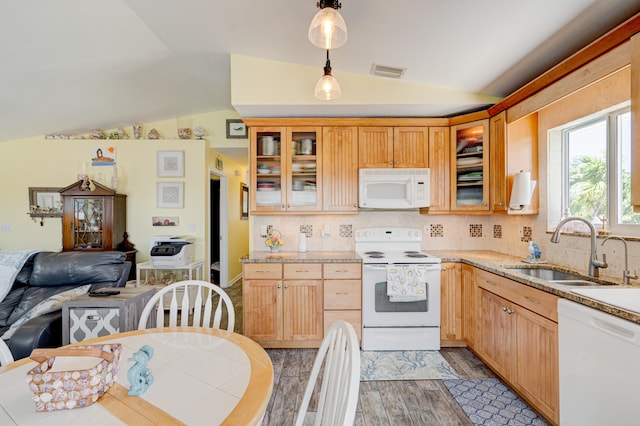 kitchen with sink, white appliances, backsplash, decorative light fixtures, and vaulted ceiling