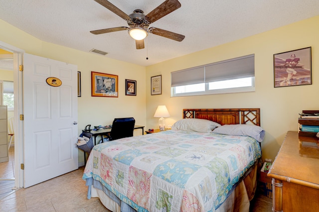 bedroom featuring ceiling fan and a textured ceiling