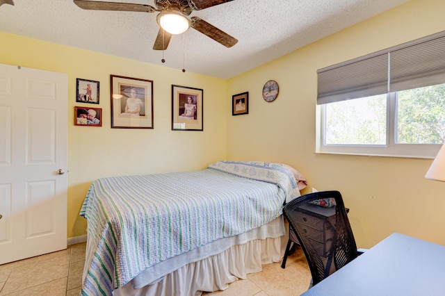 tiled bedroom featuring ceiling fan and a textured ceiling