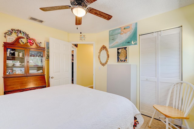 bedroom featuring ceiling fan, a closet, and a textured ceiling