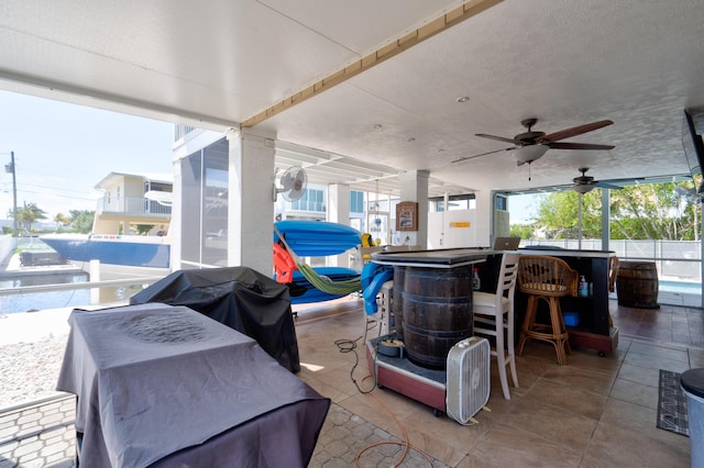 view of patio / terrace with area for grilling, ceiling fan, and exterior bar