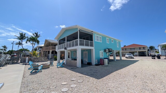 22961 John Avery Ln, Cudjoe, FL 33042 - rear view of property featuring an outdoor fire pit, a ceiling fan, a balcony, and a patio