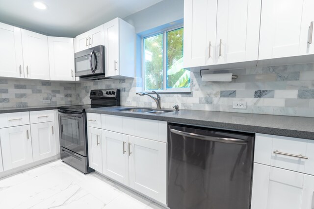 kitchen featuring white cabinetry, stainless steel appliances, sink, and backsplash