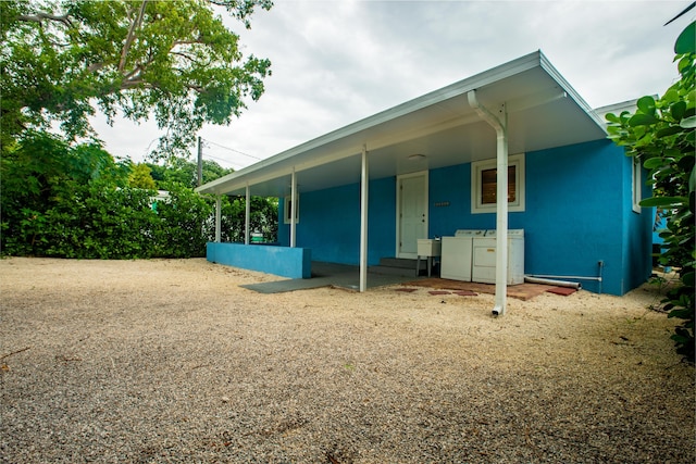 rear view of house featuring washer and clothes dryer