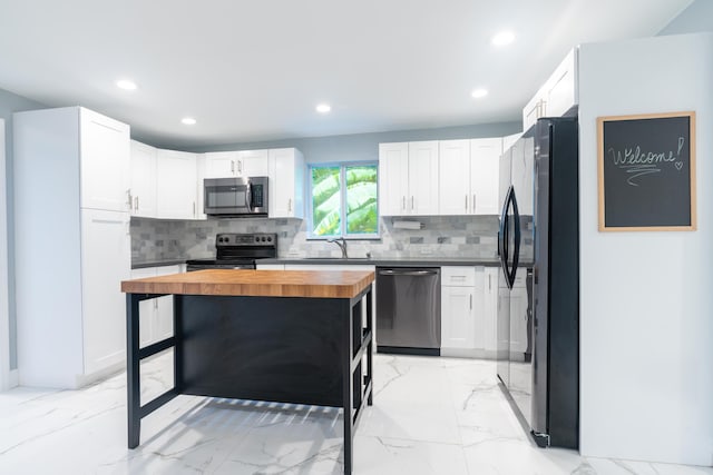 kitchen with white cabinetry, tasteful backsplash, wooden counters, and appliances with stainless steel finishes