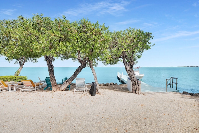 property view of water featuring a view of the beach and a dock