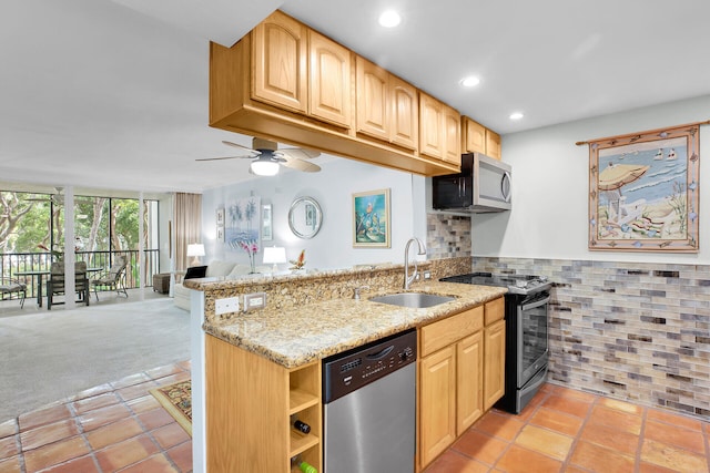 kitchen featuring appliances with stainless steel finishes, sink, light stone counters, kitchen peninsula, and floor to ceiling windows