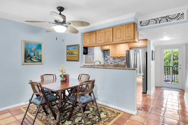 tiled dining space with crown molding and ceiling fan