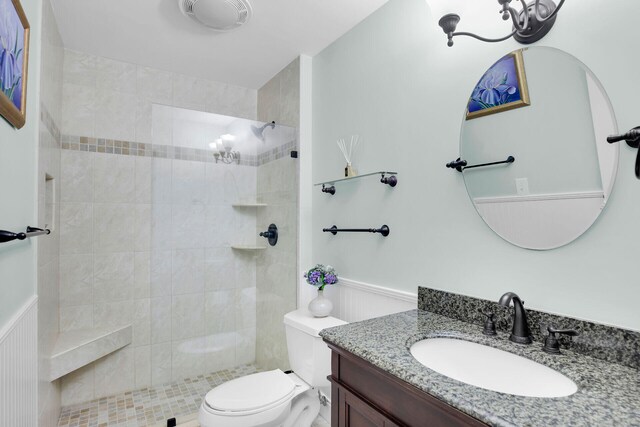 bathroom featuring tiled shower, vanity, and toilet