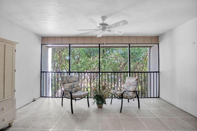 sitting room with ceiling fan, a textured ceiling, and light tile patterned floors