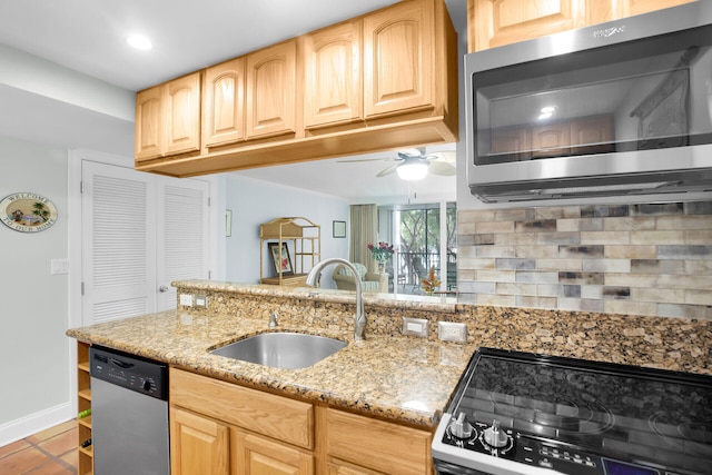 kitchen featuring light stone counters, appliances with stainless steel finishes, sink, and light brown cabinets