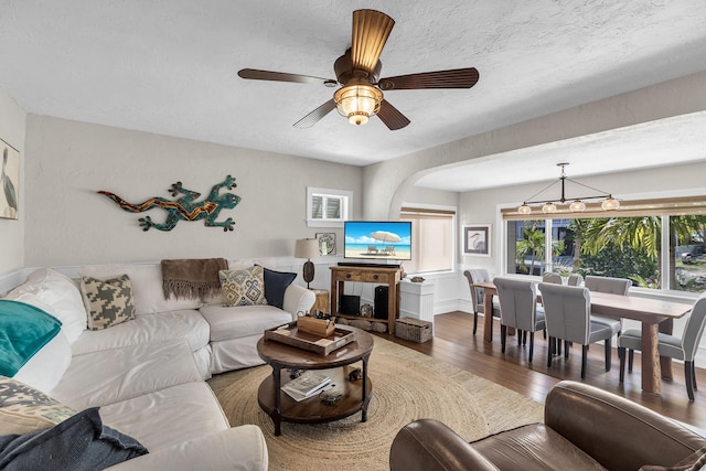 living room with ceiling fan, dark hardwood / wood-style floors, a fireplace, and a textured ceiling