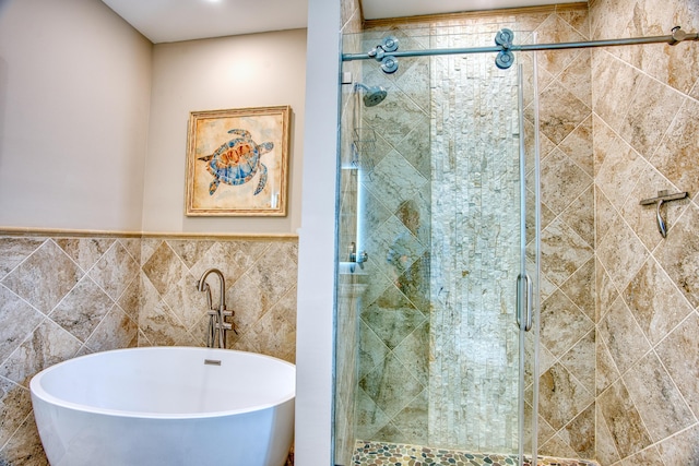 bathroom with tile walls and shower with separate bathtub