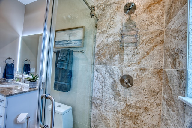 bathroom with an enclosed shower, vanity, and toilet