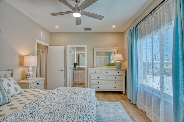 bedroom with ensuite bath, light hardwood / wood-style flooring, and ceiling fan