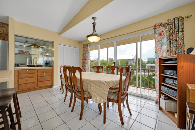 dining area with vaulted ceiling and light tile patterned flooring