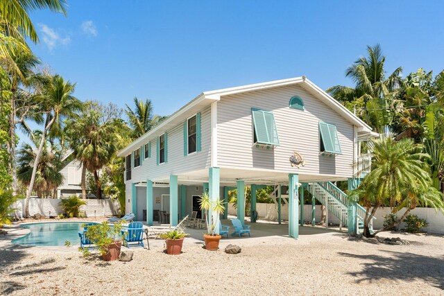 81 Jean La Fitte Dr, Key Largo, FL 33037 - rear view of house featuring a patio, a carport, and stairway