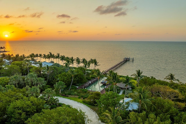 aerial view at dusk featuring a water view