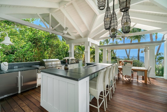 wooden deck with an outdoor kitchen, a gazebo, area for grilling, an outdoor bar, and ceiling fan