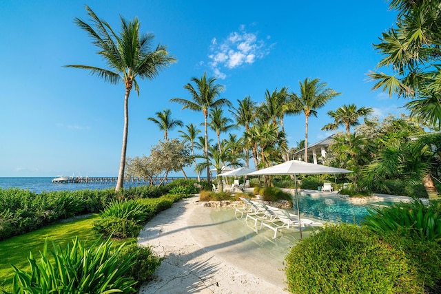 view of community with a pool, a patio, and a water view