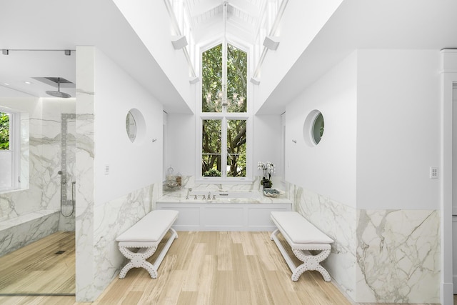 bathroom featuring wood-type flooring, separate shower and tub, and plenty of natural light