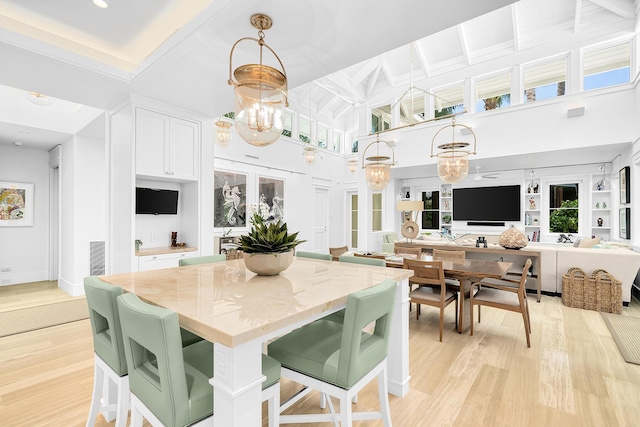 dining area featuring a notable chandelier, light hardwood / wood-style flooring, french doors, and a high ceiling