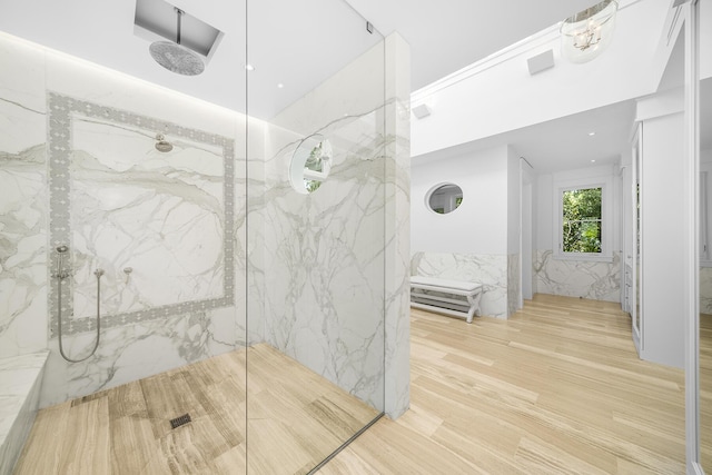 bathroom with hardwood / wood-style flooring and a tile shower