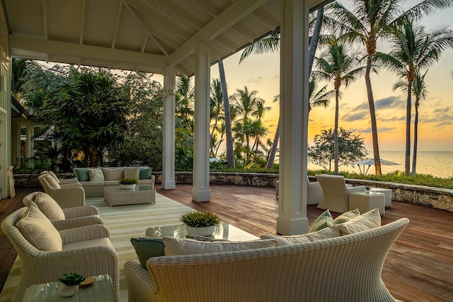 exterior space with a gazebo, a deck with water view, and an outdoor living space