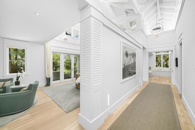 hallway featuring hardwood / wood-style flooring and high vaulted ceiling