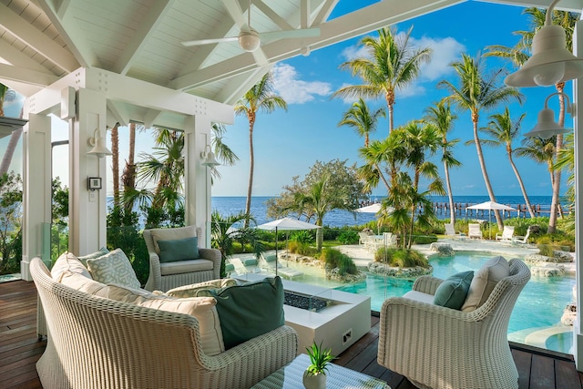 sunroom with vaulted ceiling with beams, ceiling fan, and a water view