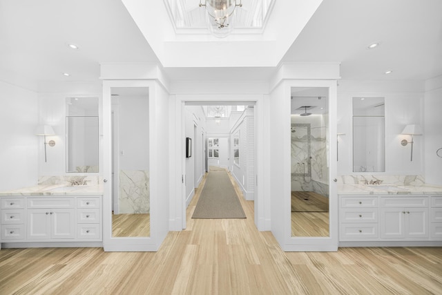 bathroom with crown molding, wood-type flooring, vanity, and a tile shower