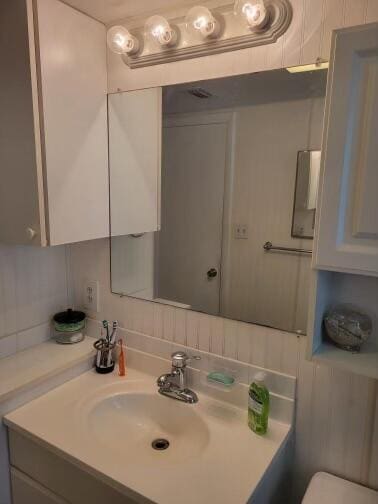 bathroom featuring vanity and backsplash