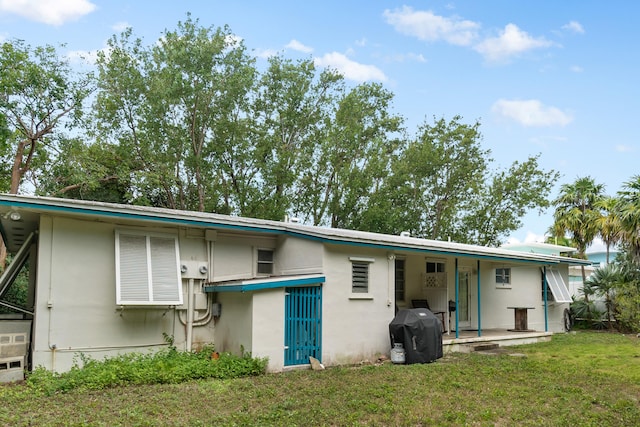 228-230 Apache St, Tavernier, FL 33070 - back of property featuring stucco siding and a yard