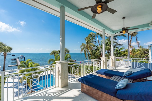 view of patio with a water view, a balcony, and a ceiling fan