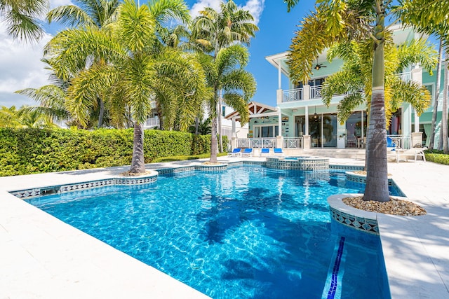 view of swimming pool with fence, a pool with connected hot tub, ceiling fan, and a patio area