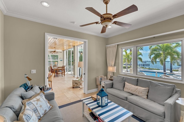 living room featuring stone tile flooring, plenty of natural light, and crown molding