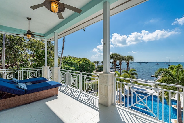 balcony with a water view and a ceiling fan