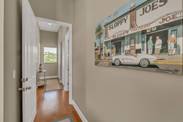 hallway featuring wood finished floors and baseboards