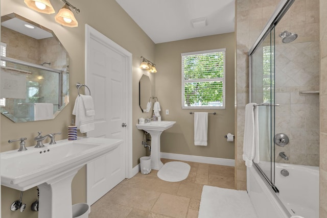 bathroom featuring a sink, baseboards, and enclosed tub / shower combo