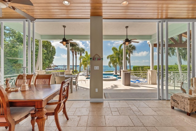 sunroom / solarium featuring plenty of natural light, wood ceiling, and a ceiling fan