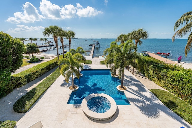 view of swimming pool featuring a patio area, a water view, a dock, and a pool with connected hot tub