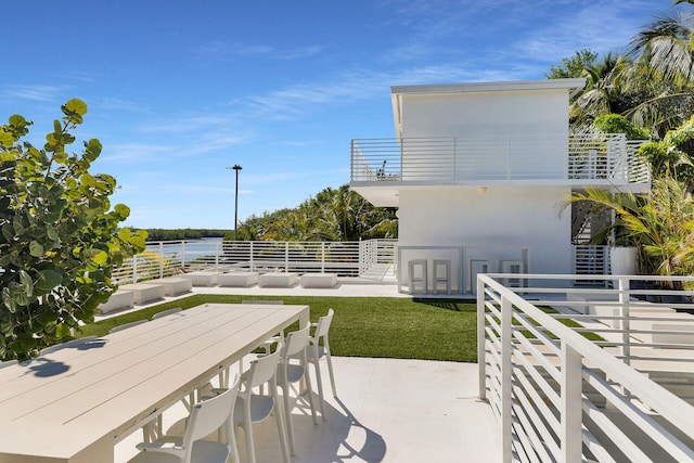 view of patio with a water view and a balcony