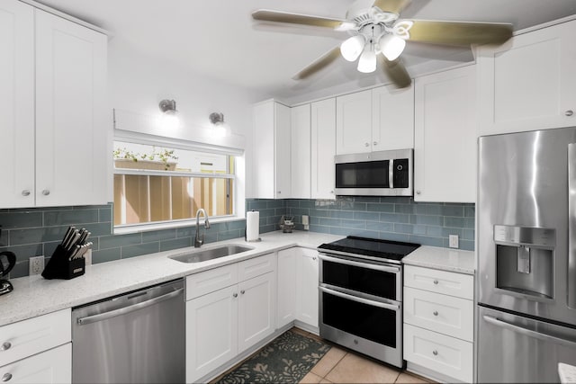 11554 5th Ave, Ocean, Marathon, FL 33050 - kitchen with stainless steel appliances, a sink, a ceiling fan, white cabinets, and backsplash