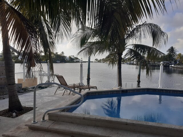 view of pool featuring a patio and a water view