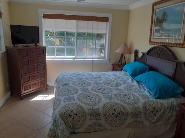 tiled bedroom featuring multiple windows and ornamental molding