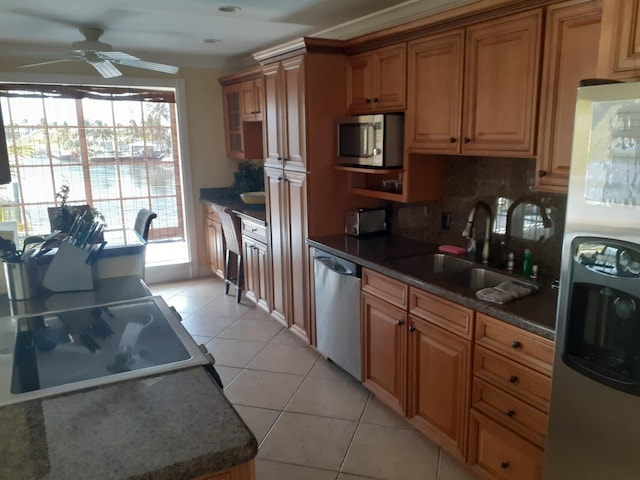 kitchen with sink, tasteful backsplash, light tile patterned floors, ceiling fan, and stainless steel appliances