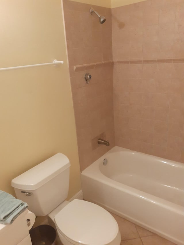 bathroom with tile patterned floors, toilet, and tiled shower / bath