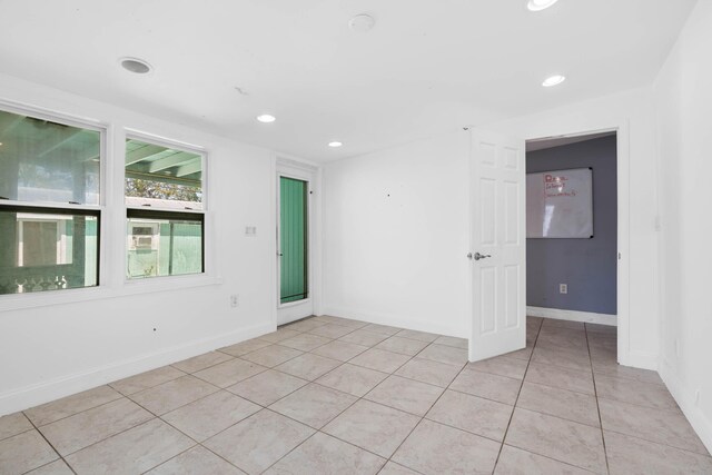 spare room featuring crown molding, baseboards, and wood finished floors