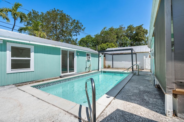 outdoor pool with an outdoor structure, a patio, and fence