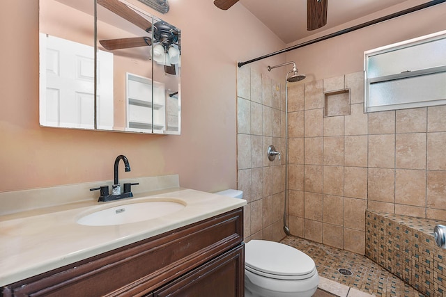 full bathroom featuring vanity, toilet, a ceiling fan, and a tile shower